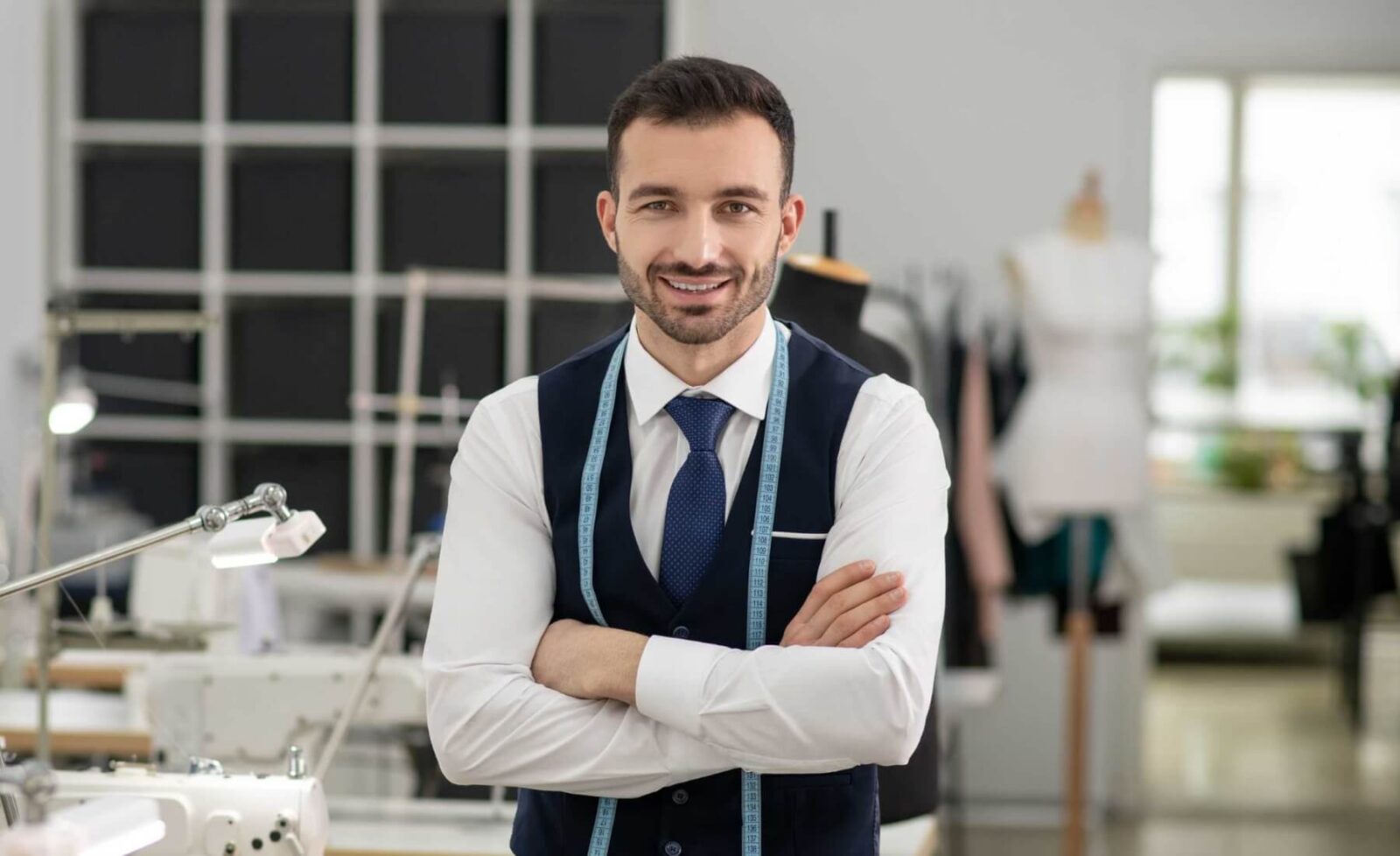 male-tailor-standing-with-folded-hands-smiling-6XDBDYM.jpg