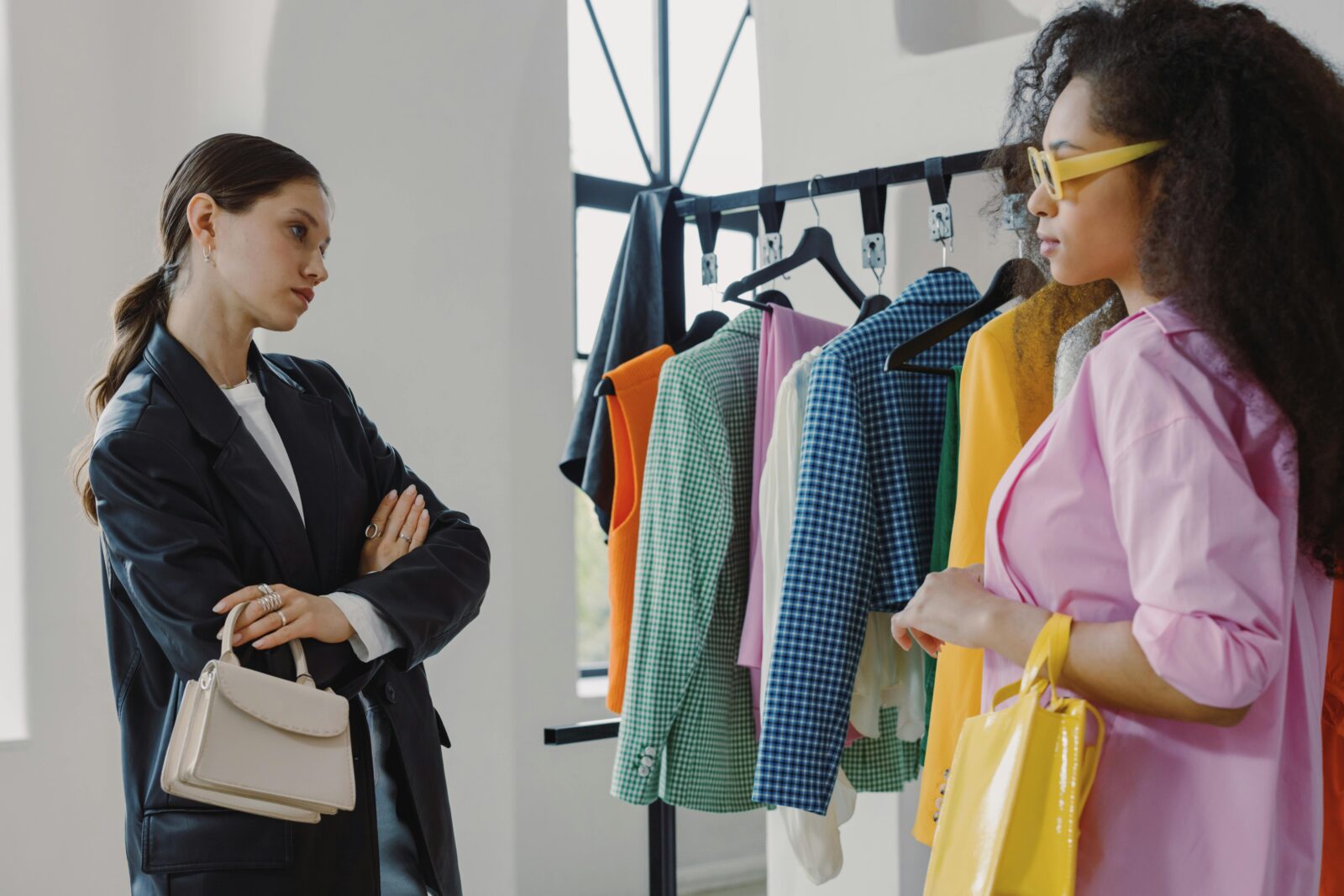 Two women browsing colorful clothing racks in a modern boutique.