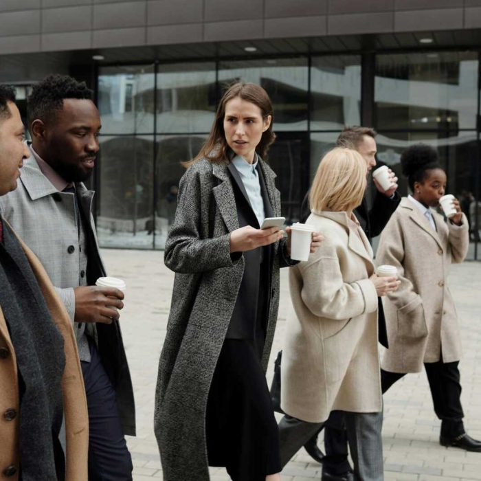 A group of diverse business professionals enjoying a coffee break outdoors in the city.